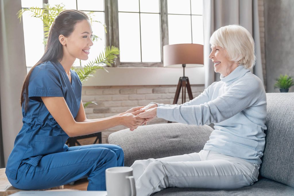 female clinician assisting senior hold out their hand